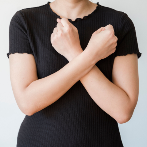 Person holding their arms close to their body during an anxious or overwhelmed moment