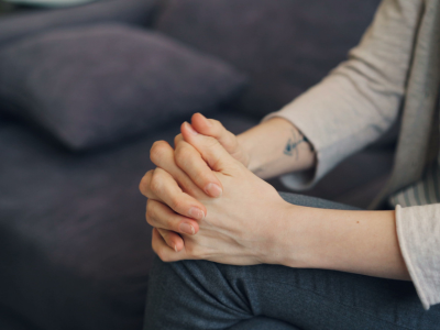 Person clasping their hands while experiencing anxiety or stress