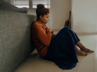 Woman sitting on the floor alone while feeling anxious and overwhelmed