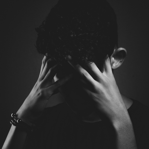 Person covering their face while experiencing emotional distress